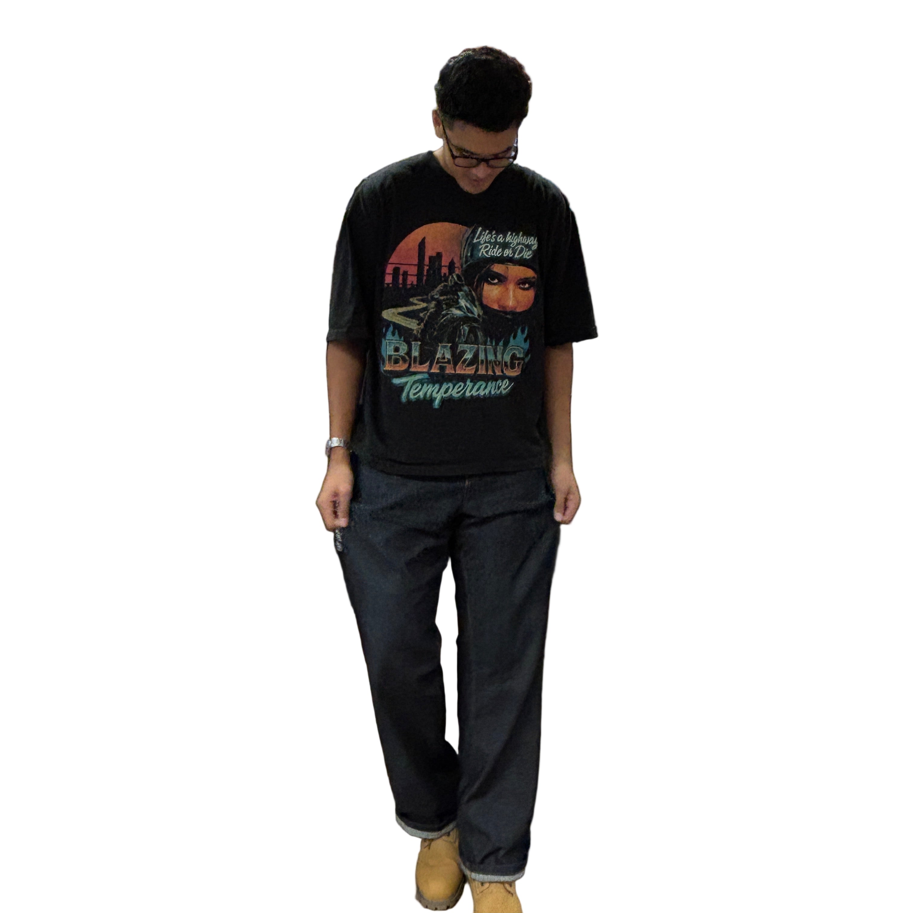 Person wearing a graphic t-shirt and dark pants on a black background